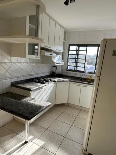 阿瓜斯-迪圣佩德罗Apartamento 32 no centro de Águas de São Pedro的厨房配有白色橱柜和冰箱。