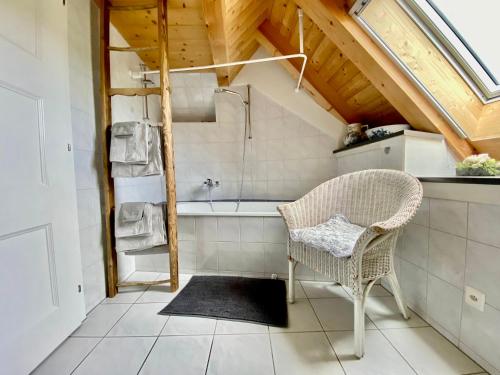 吉尔森西Rosenhüsli的一间带椅子和浴缸的浴室