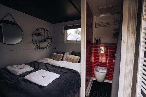 塞尔福斯Golden Circle Truck Hotel的一间小卧室,配有一张床和一个卫生间