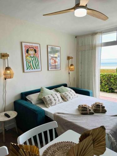 拉皮内达Apartamento Boutique en la Playa的一间卧室设有两张床、一张桌子和一个窗口