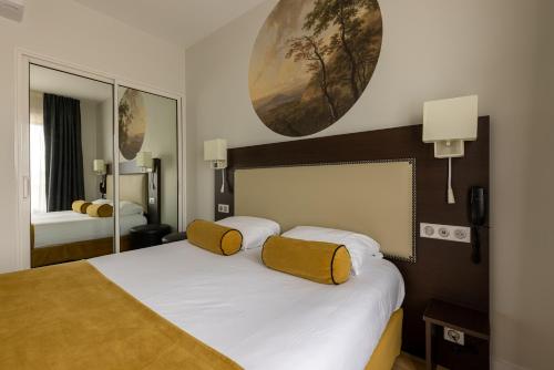 贝尔热拉克Brit Hotel Europ Bergerac的卧室配有一张带黄色枕头的大型白色床。