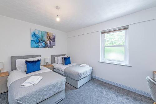 普雷斯顿St Pauls Square Holiday Home - Preston的一间卧室设有两张床、一张沙发和一个窗口