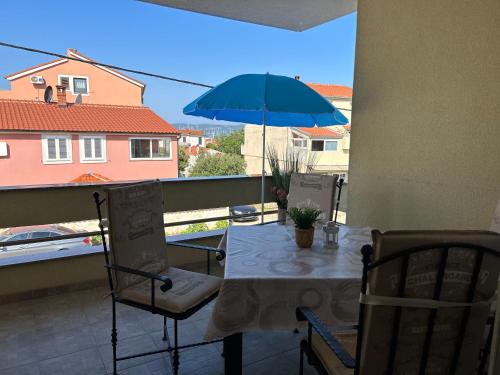 比奥格勒·纳·莫鲁Apartment David的阳台配有带蓝伞的桌椅