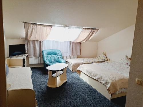 陶格夫匹尔斯Saules rati的酒店客房,设有两张床和一张蓝色椅子