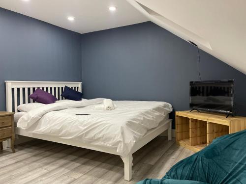 伦敦EAST LONDON APARTMENTS SELF check in的卧室配有白色的床和蓝色的墙壁