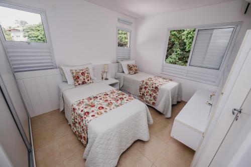 科斯塔萨乌佩Beach House Sauípe的小房间设有两张床和两个窗户