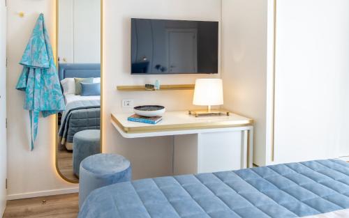里乔内蒂法尼酒店的一间卧室配有一张床、一台电视和一张桌子