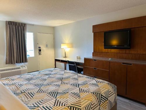 福雷斯特城Motel 6 Forrest City AR的配有一张床和一台平面电视的酒店客房