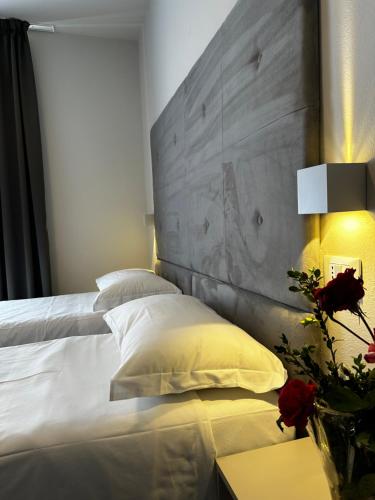 卡沃PFA Hotel - Isola d'Elba的一间卧室配有一张白色床和混凝土床头板