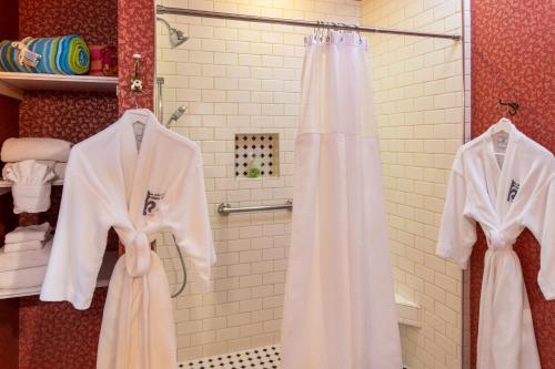 费南迪纳比奇Amelia Island Williams House的浴室提供白色浴袍和淋浴。