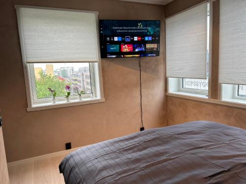 卑尔根MK8 Apartment的一间卧室设有2扇窗户和1张床铺