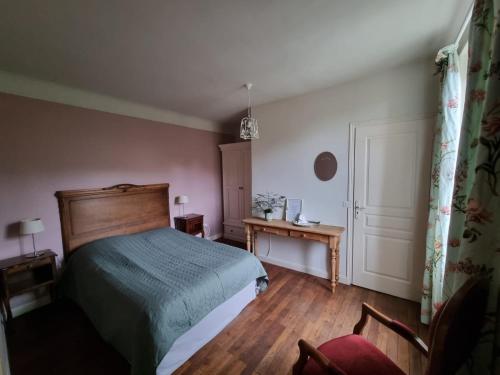 Saint-Amand-JartoudeixBon Chez Nous的卧室配有1张床、1张桌子和1把椅子