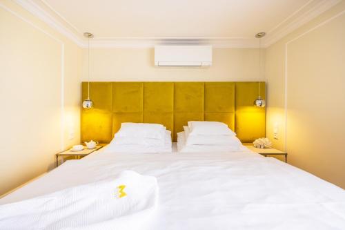 波杰布拉迪Mamma´s Boutique Hotel的一间卧室配有两张带白色床单的床