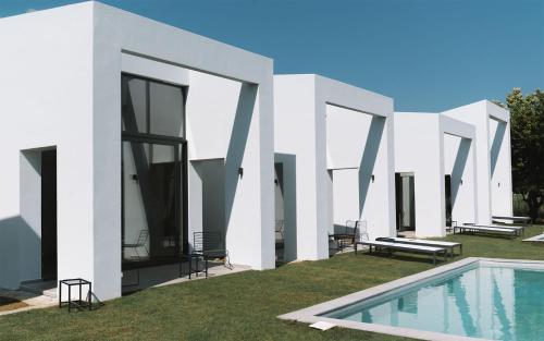 PetroúlaiSevene Villas的一座带庭院游泳池的白色房子