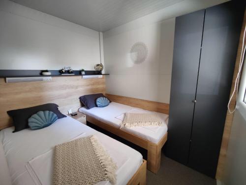 德拉格ARIA Mobile Home, Oaza Mira 5 Star Camping, Dalmatia的小房间设有两张床和橱柜
