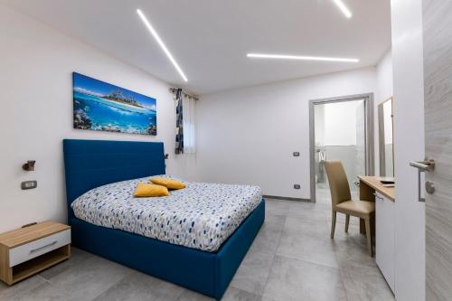 圣塔马利奈拉BNB Aria di Mare的一间卧室配有蓝色的床和一张书桌