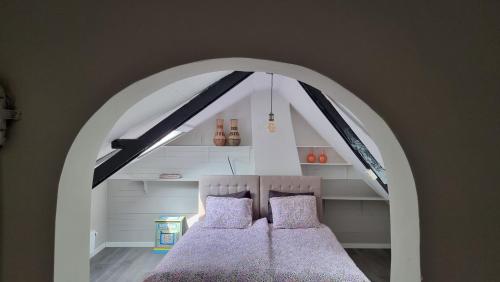 坎珀兰't Bakuusje的一间带拱门的卧室,其中配有两张床