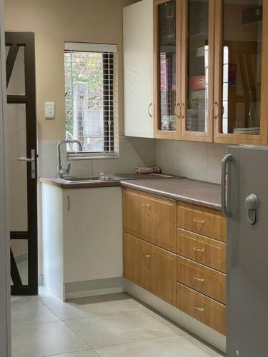 约翰内斯堡Side Step的厨房配有木制橱柜和不锈钢冰箱。