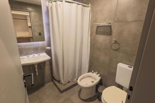 圣卡洛斯-德巴里洛切HOTEL CONCEPT BARILOCHE的浴室配有白色的浴帘和卫生间
