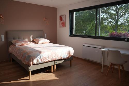 BoharsMaison contemporaine aux portes de Brest的一间卧室配有一张床、一个窗口和一张书桌
