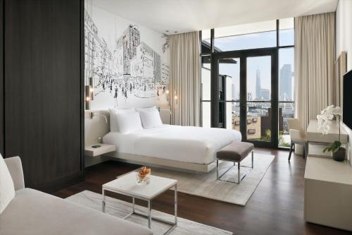 迪拜迪拜城市漫步傲途格精选酒店的一间带白色床的卧室和一间客厅