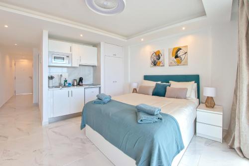 法纳贝海滩Buena Vista Ponderosa 517的一间白色卧室,配有一张大床和一个厨房