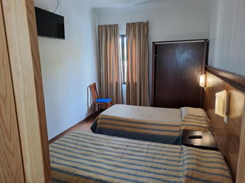 大里贝拉Hotel Ribeira Grande的酒店客房,配有带条纹毯子的床