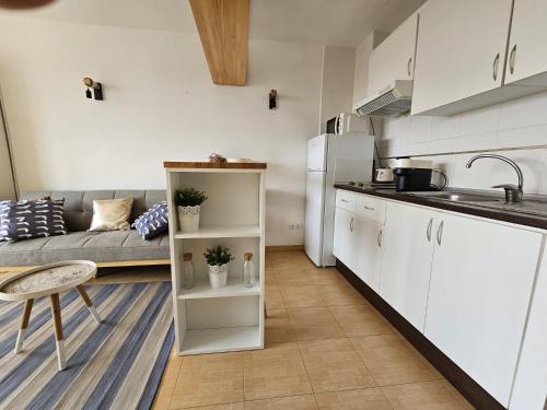 阿尔梅利马Coqueto estudio cerca del mar的厨房以及带白色橱柜和沙发的客厅。