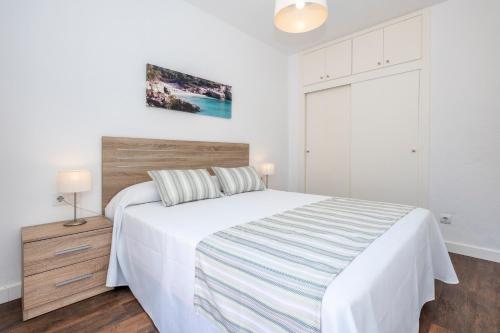 休达德亚勒贝格公寓的卧室配有白色的床和木制床头板