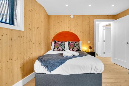 布莱顿霍夫Green Mews 3 with Free Parking - By My Getaways的一间卧室设有一张大床和木墙