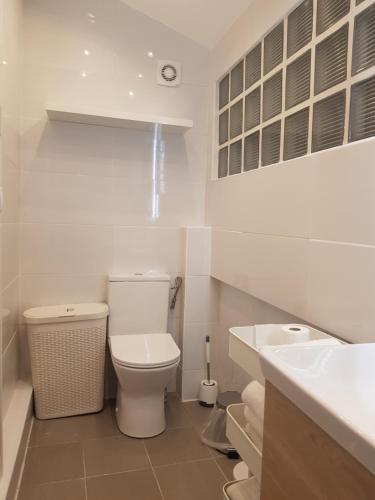Pavillons-sous-BoisCharmante villa proche de la gare et de Paris的白色的浴室设有卫生间和水槽。