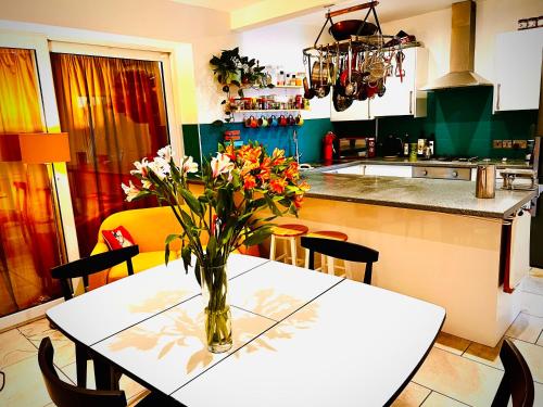 锡福斯Liverpool - Cosy Jazzy Beach Home!的厨房配有一张桌子,上面放着花瓶