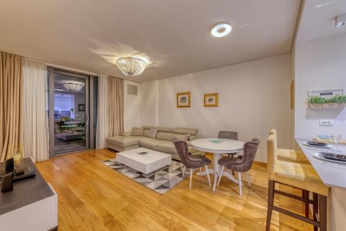 贝尔格莱德Queen Apartments Belgrade Waterfront的客厅配有桌子和沙发