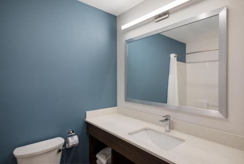 奥斯汀WoodSpring Suites Austin Central的一间带水槽、镜子和卫生间的浴室