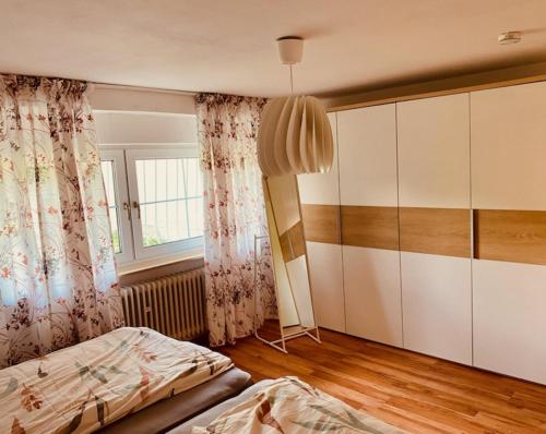 美茵河畔哈瑙GARDEN VIEW near FRANKFURT ----- STAY LIKE AT HOME -----的一间卧室配有一张床和一个大型橱柜