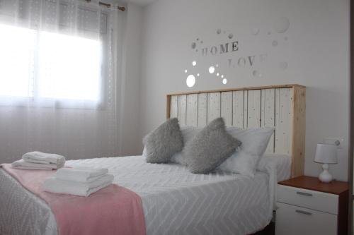 代尔特布雷El Racó de Yleth的卧室配有带枕头的白色床和窗户。