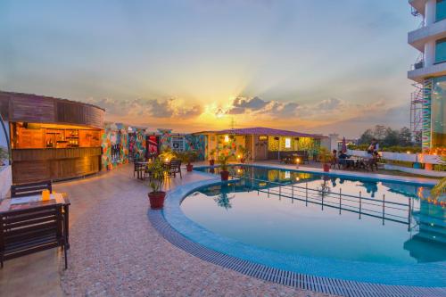 德拉敦苏丽黛尔酒店的一座酒店游泳池,享有日落美景