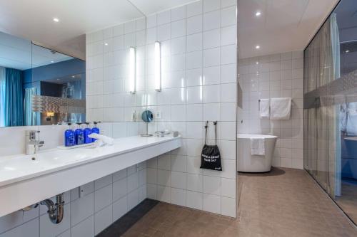 赫尔辛堡赫尔辛堡大都会丽笙酒店的浴室设有2个水槽和镜子