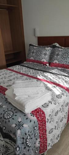 阿罗萨新镇Piso As Rodas的床上有红色和白色的被子