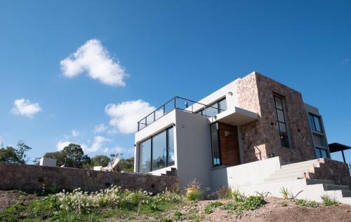 拉库布蕾Casa en la naturaleza con vistas a las Sierras的蓝天山上的房子