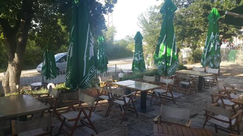 希科尔皮诺夫西Ваканционно селище СБХ的一组桌椅,配有绿色遮阳伞