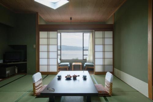 诹访市Suwakoen的客房设有桌椅和大窗户。