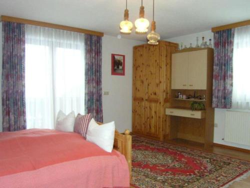 格绍Charming holiday home in Gosau的一间卧室配有一张带红色毯子的床