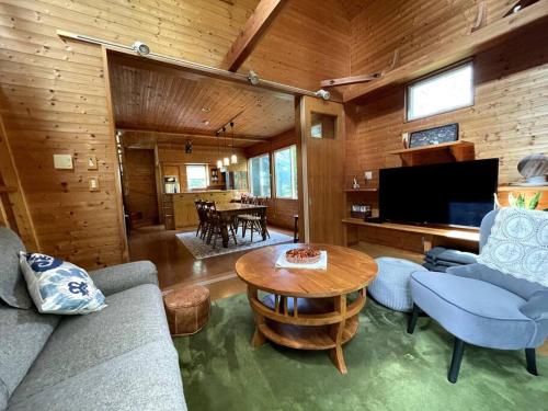 山中湖村4月リニューアルOpen! 全室エアコン完備! Deerview Lodge 山中湖的客厅配有沙发和桌子
