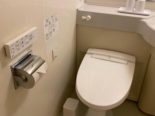 名古屋名古屋荣微笑酒店的一间带卫生间和卫生纸分配器的浴室