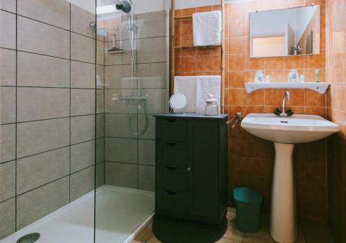 圣保罗莱达莱斯阿加西亚斯酒店的浴室设有绿色橱柜,旁边设有水槽和淋浴