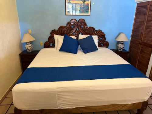 巴亚尔塔港Vallarta Sun Suites的一间卧室配有一张带蓝色枕头的大床