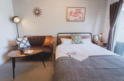 大阪川HOUSE黒門的一间卧室配有一张床、一张沙发和一张桌子