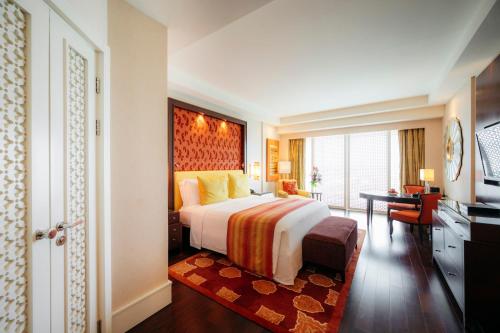 班加罗尔班加罗尔丽思卡尔顿酒店的酒店客房设有一张大床和一张书桌。