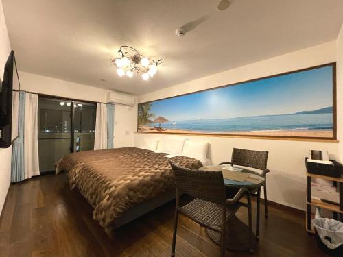 名户Ao Hotel的一间卧室配有一张床、一张桌子和一个大窗户